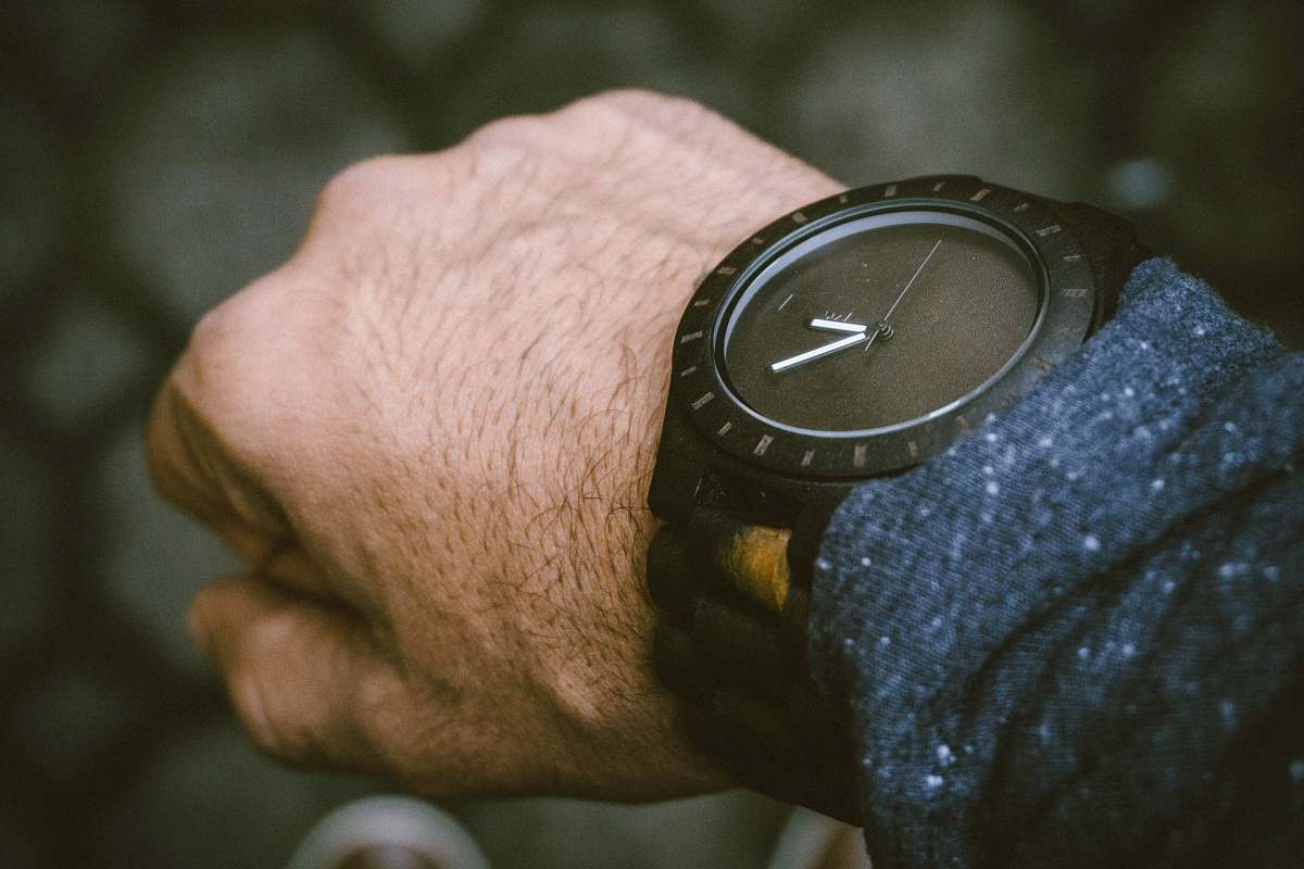 wrist round black analog watch in left human wrist digital watch