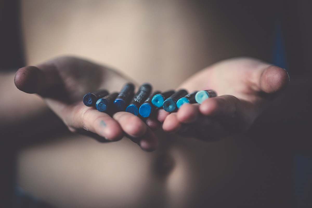 person person holding blue crayons hands