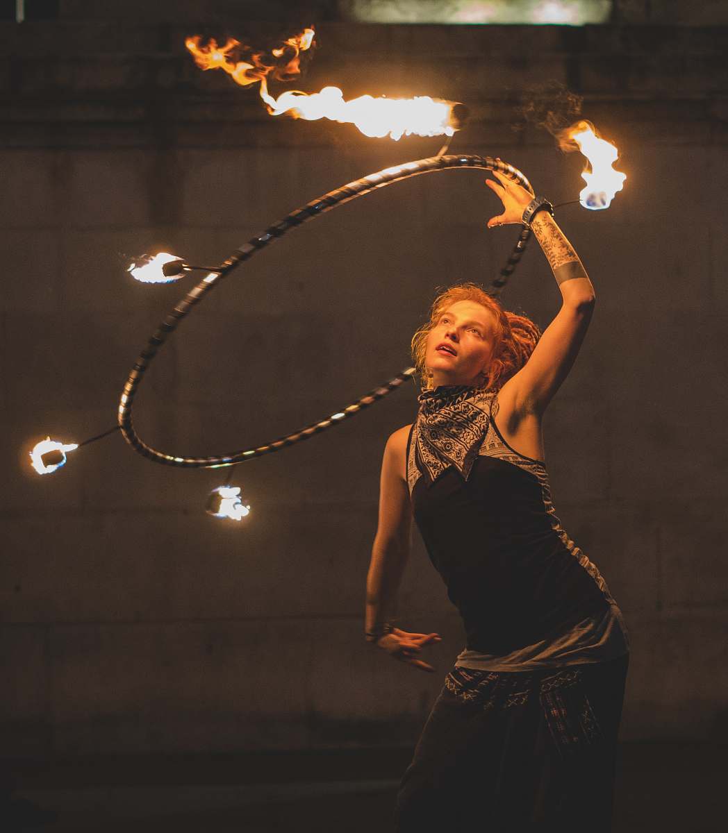 person woman fire dancing with hoop during nighttime london