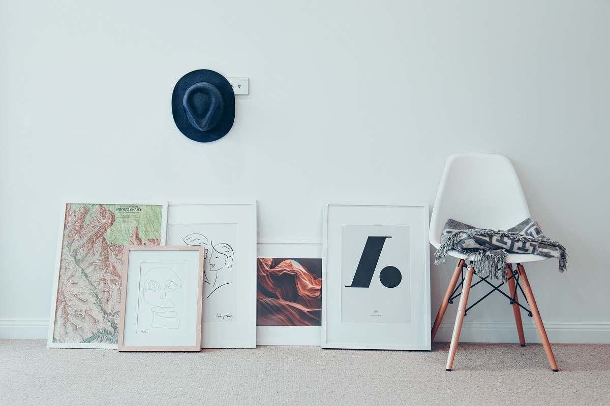 chair white chair beside five paintings furniture