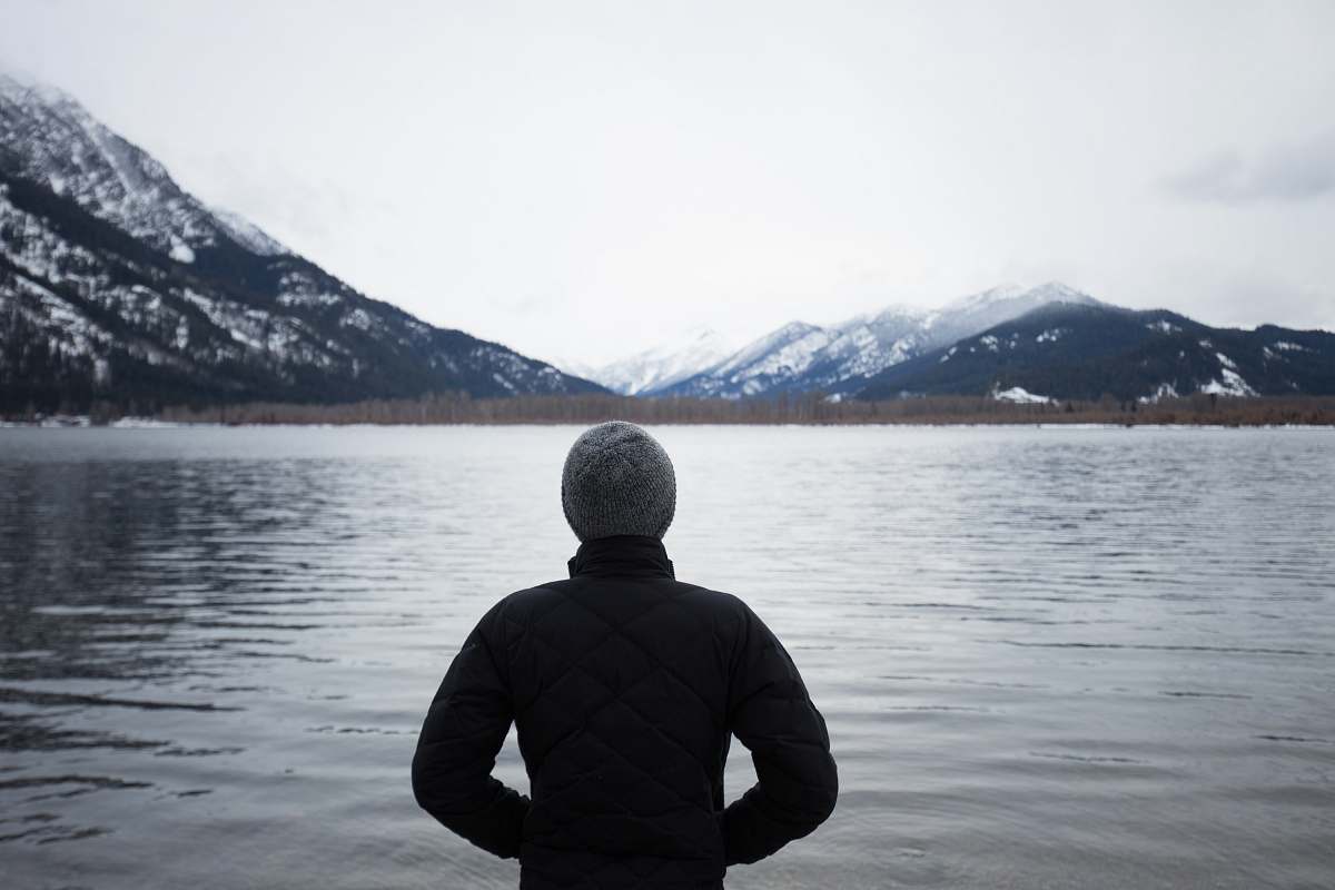 people man in black top standing in front of lake human