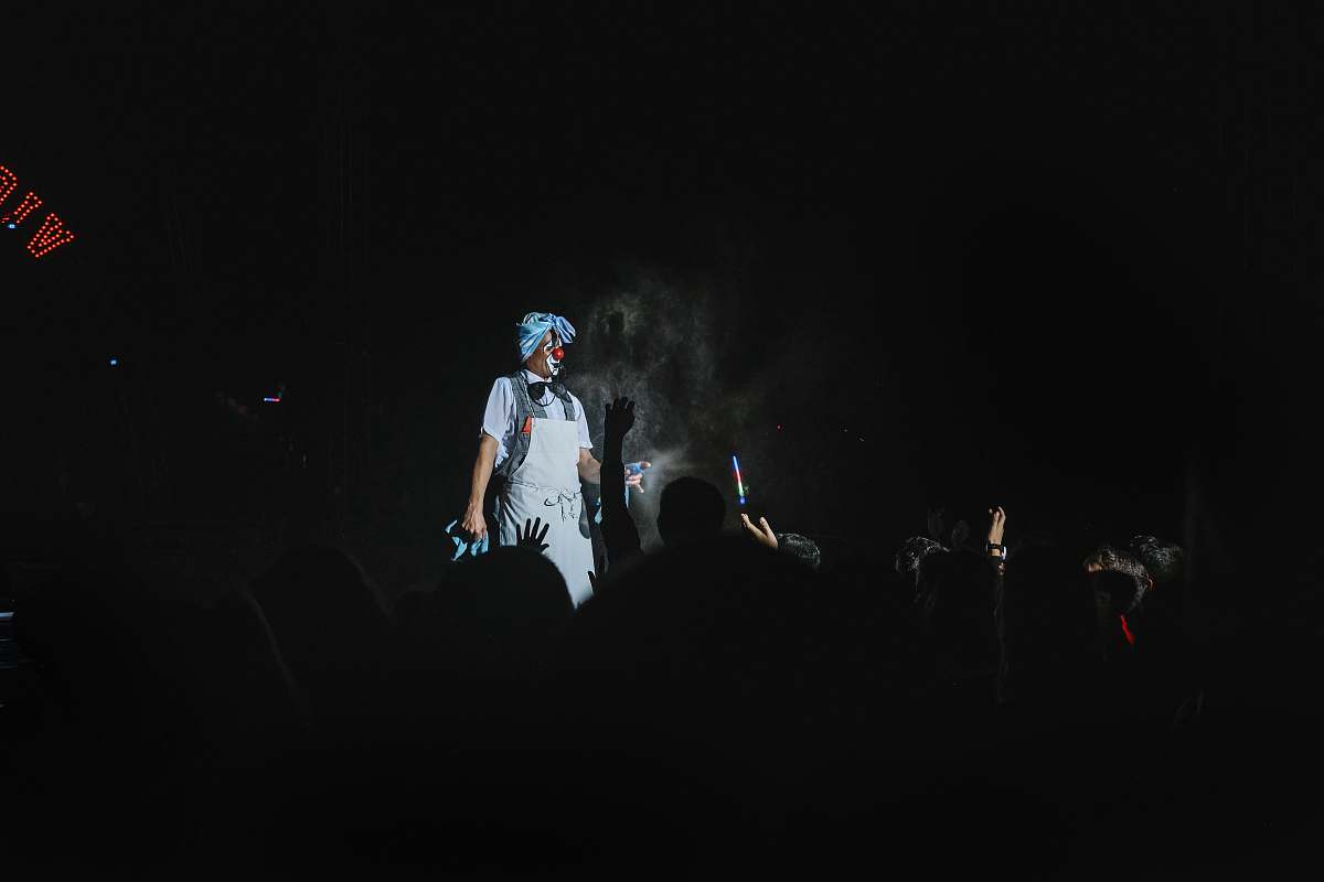 human man standing while wearing white shirt stage