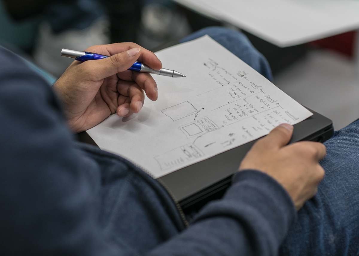 human person writing on paper at lap text