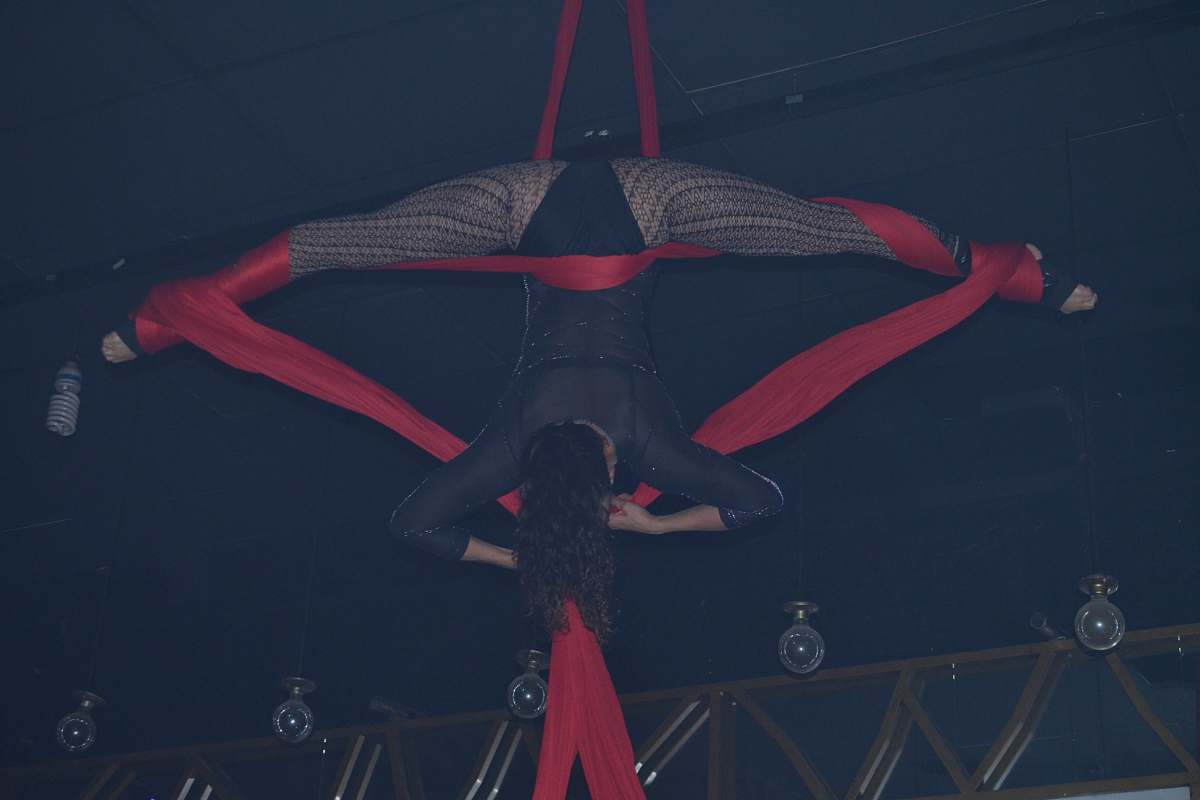 human woman wears black shirt hanging on red strap close-up photography acrobatic