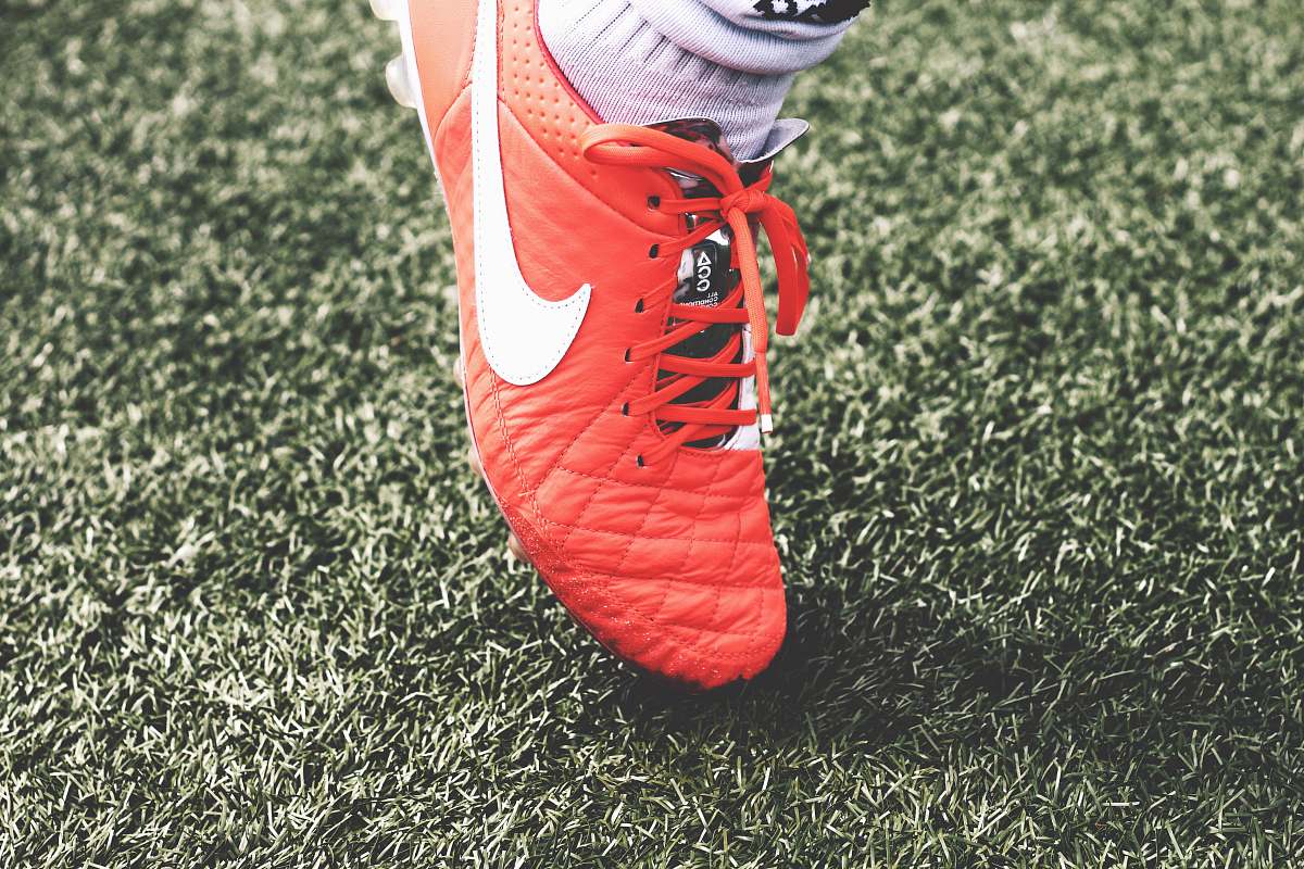 soccer unpaired orange and white Nike soccer cleat shoe