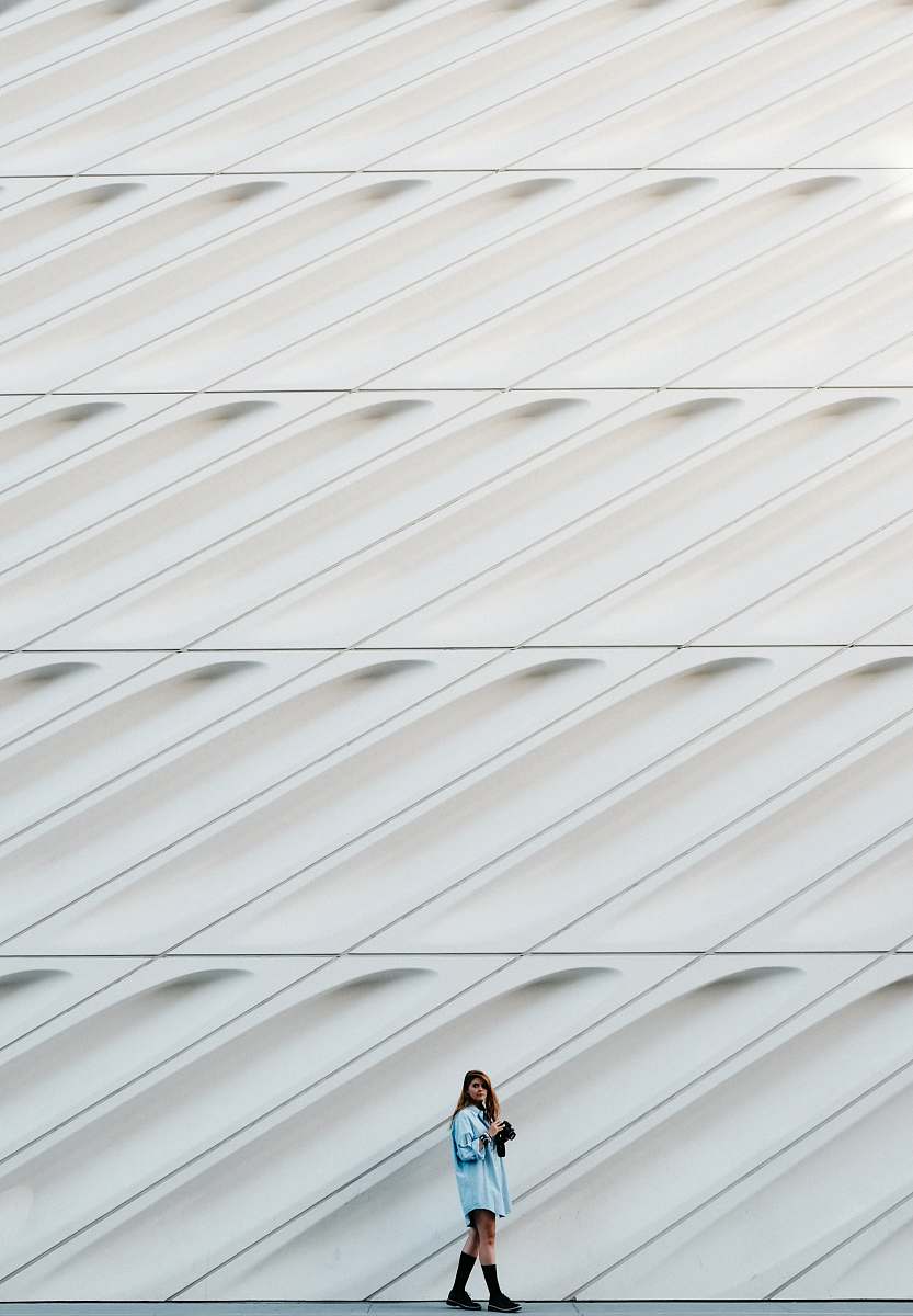 pattern woman standing beside white concrete wall wall