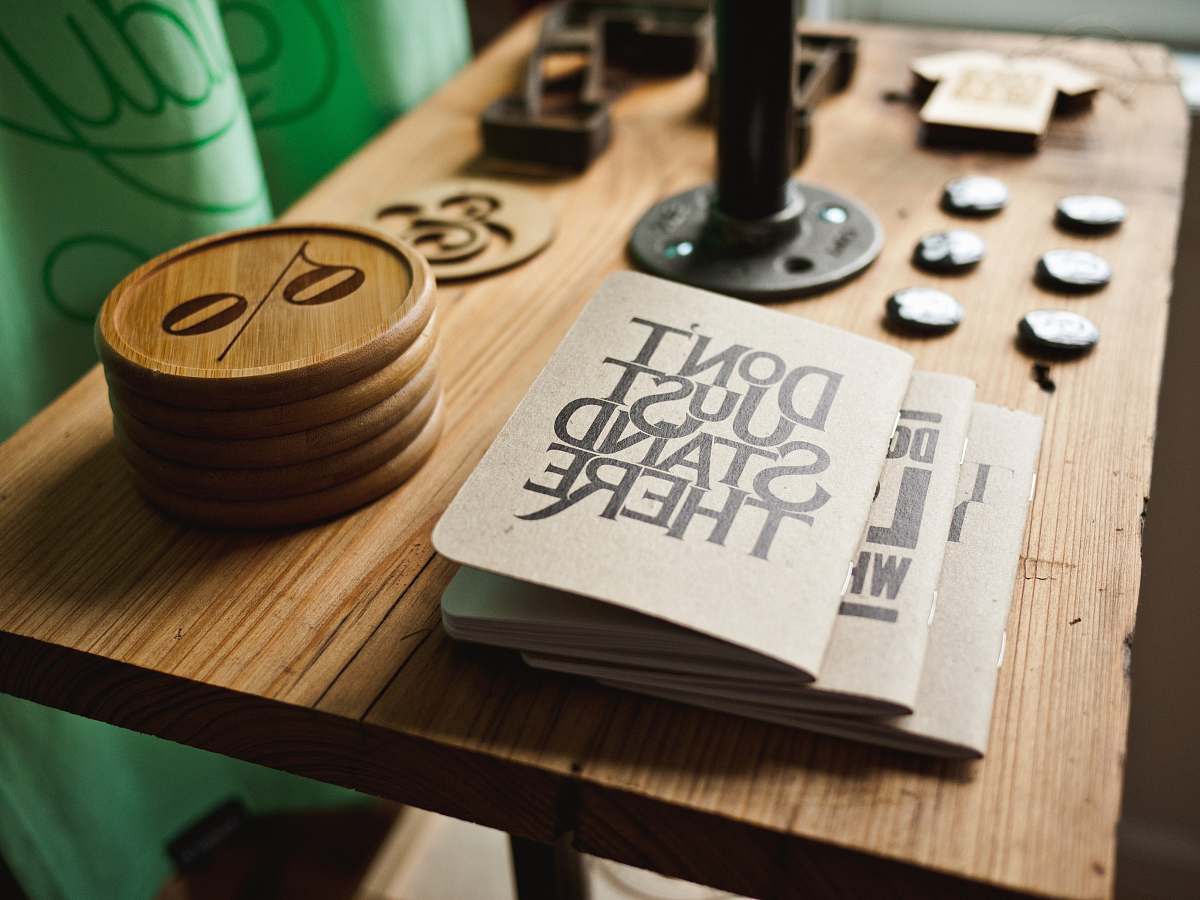 table three gray papers near round brown wooden boards on table trinkets