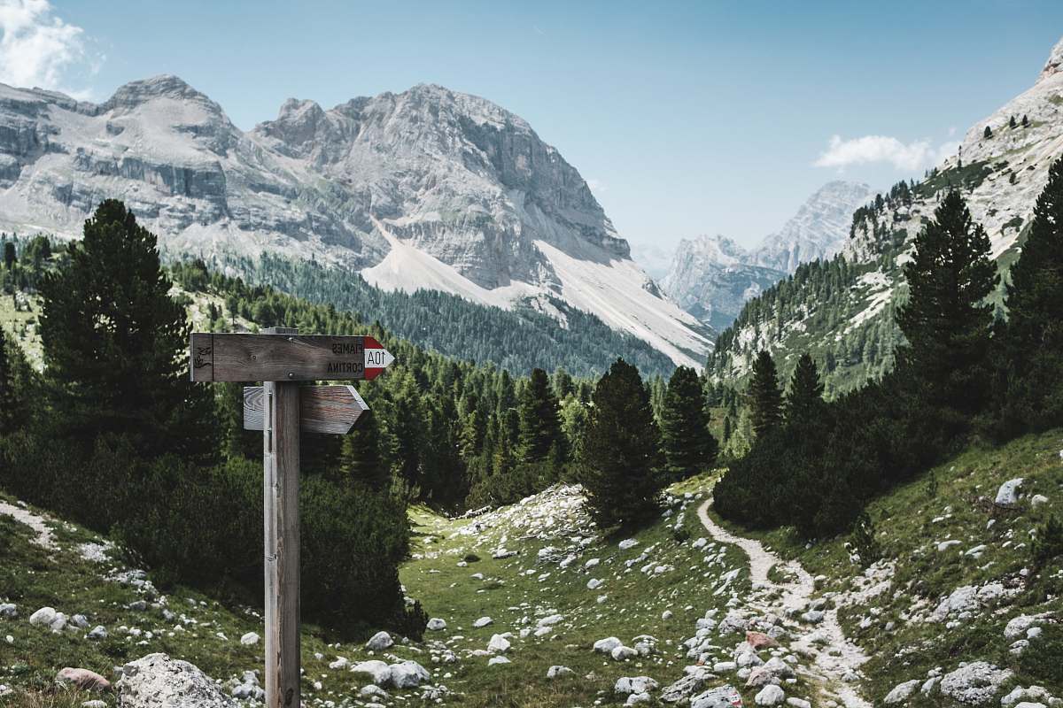 nature Mountain landscape with signs pointing toward a rocky hiking path mountain