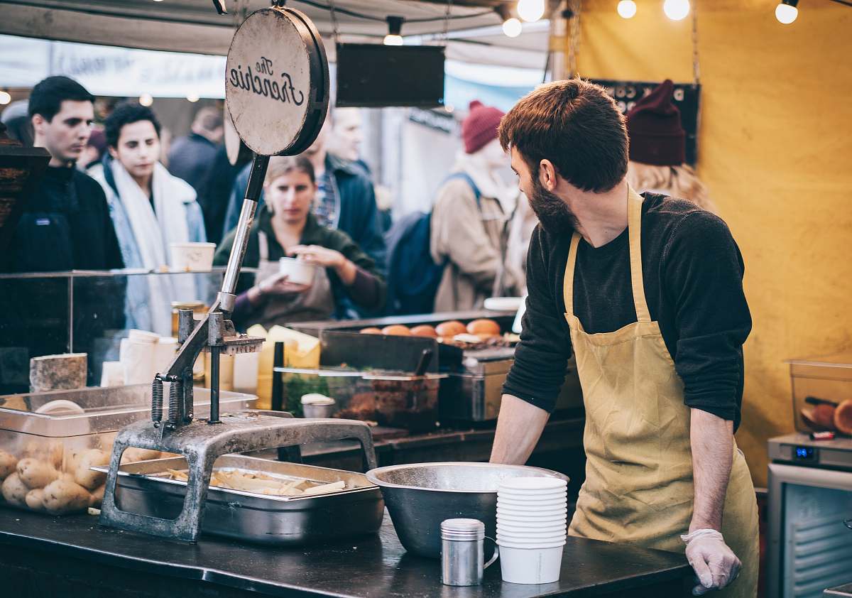 person man leaning hand on table looking on group of people people