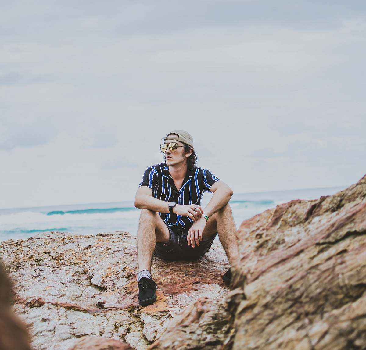 person man sitting on brown rock outdoors