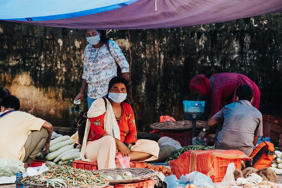 person woman in white and red dress sitting on brown woven basket market