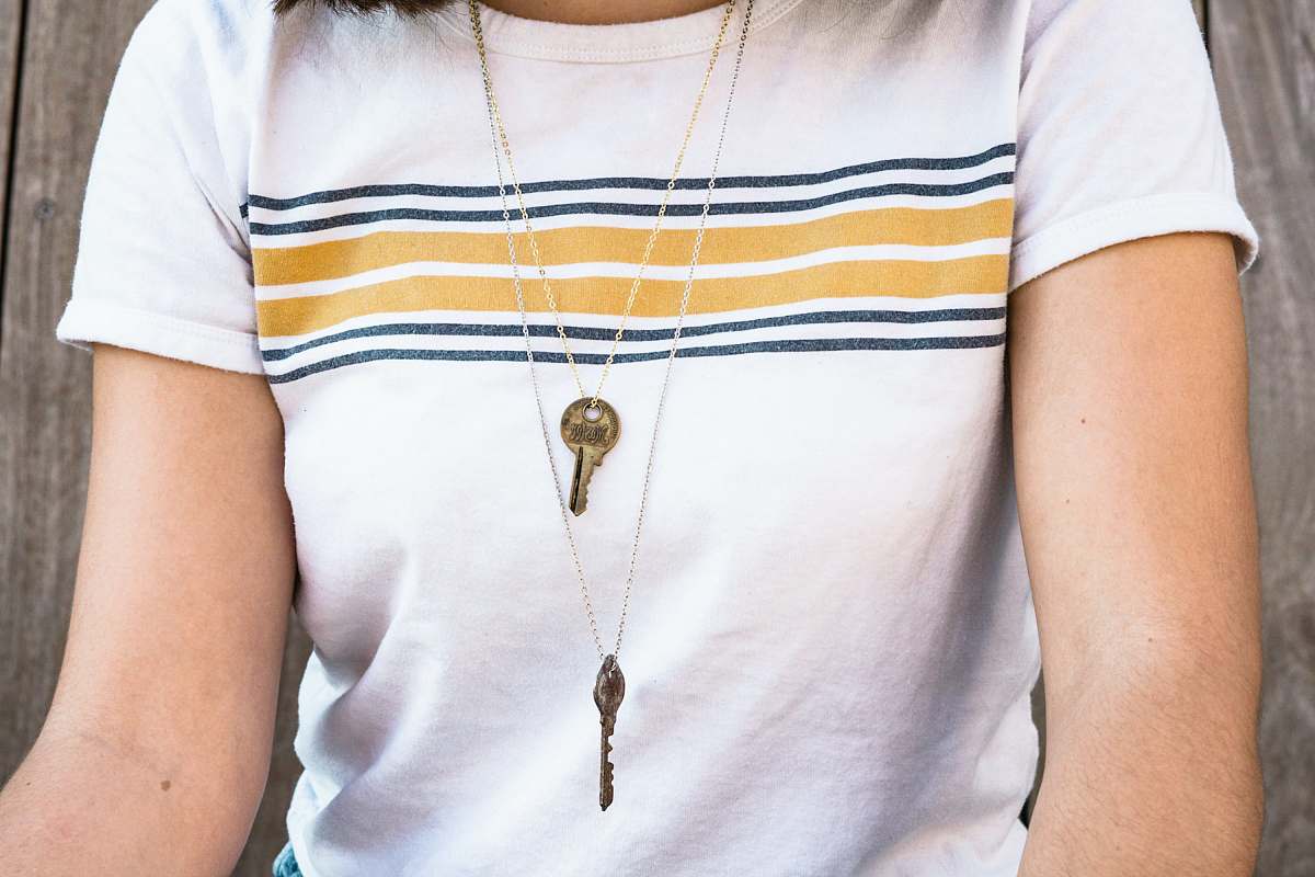 person woman wearing silver-colored key pendant necklace pendant
