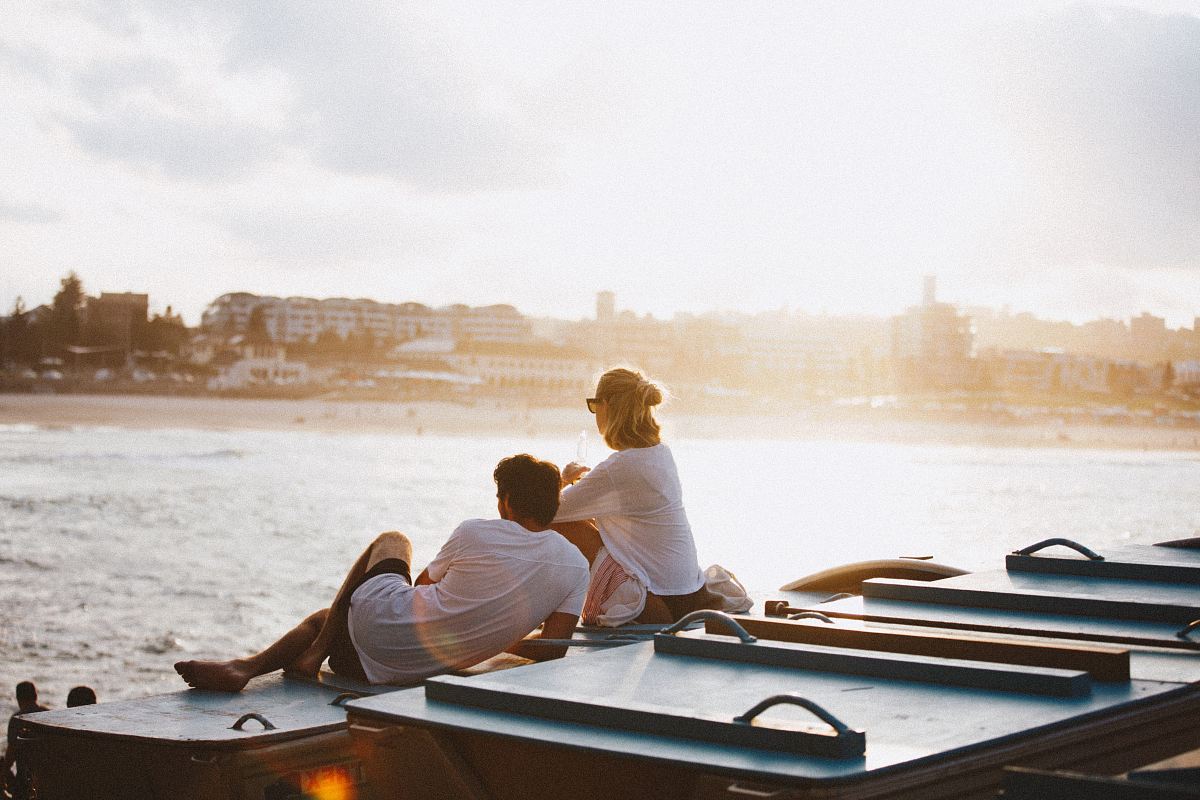 couple sitting on boat in front of body of water