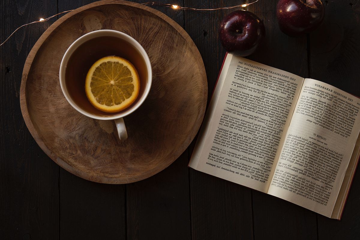 top view of open book and cup with lemon inside