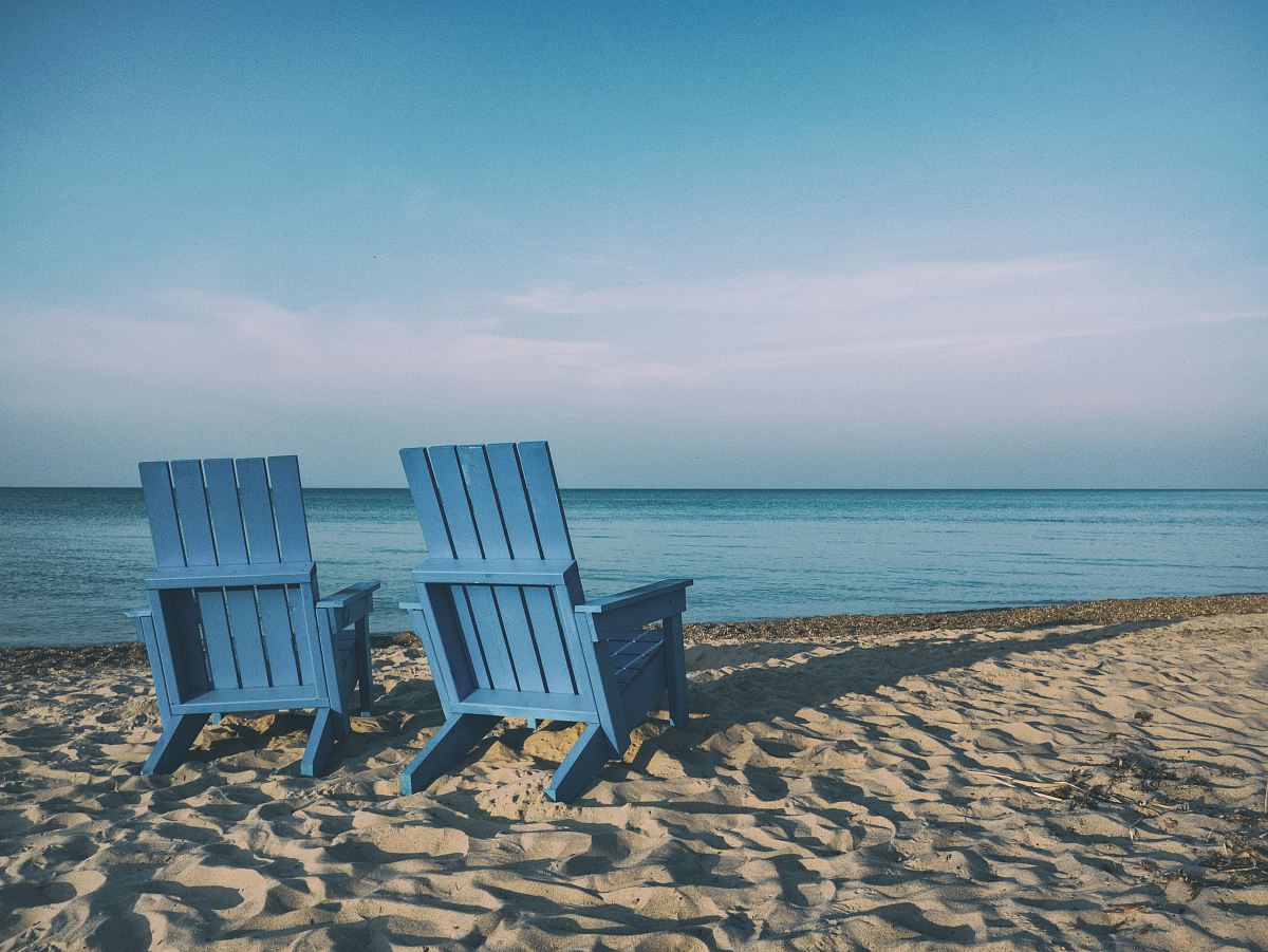 two blue beach chairs near body of water