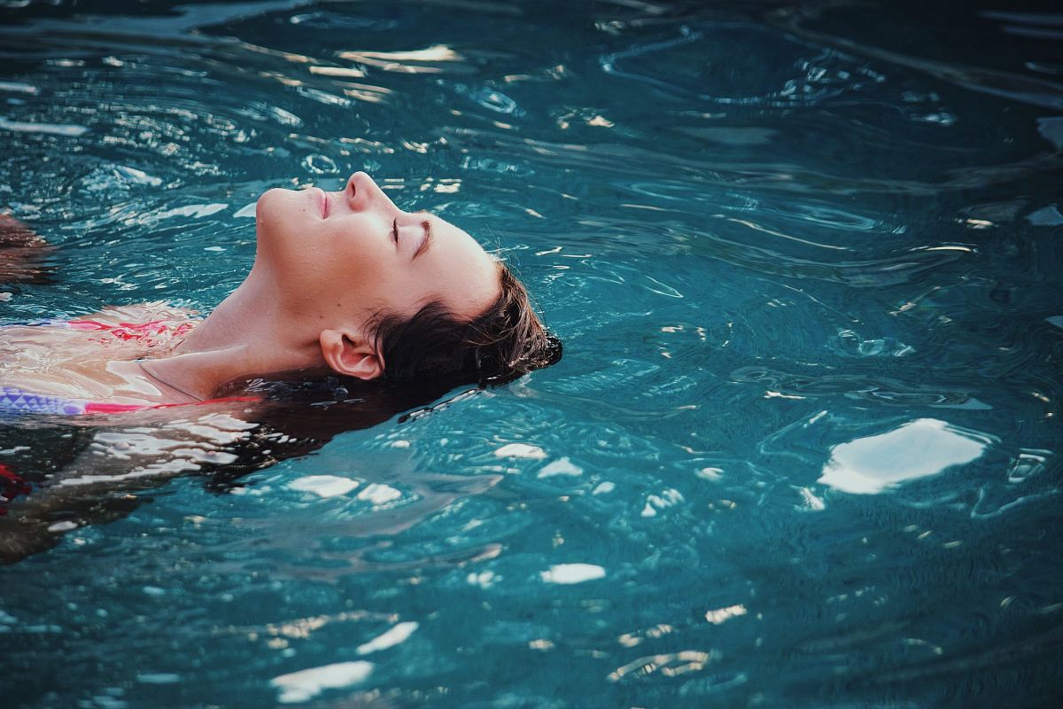 woman floating on body of water