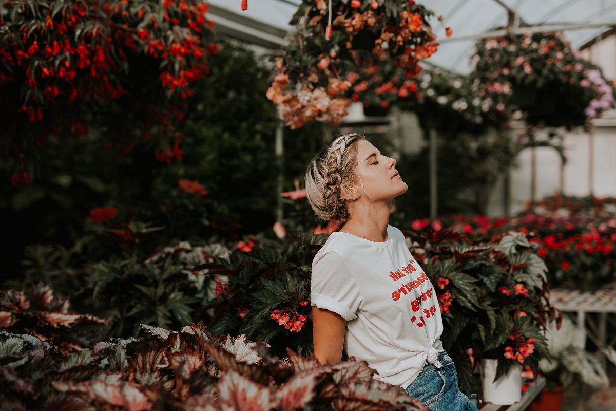 woman wearing white shirt standing near the flower