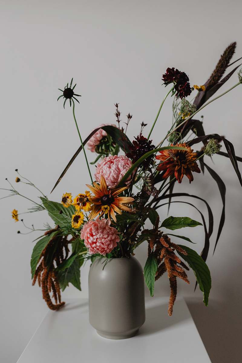 flower yellow and pink flowers in grey vase on white surface flower arrangement