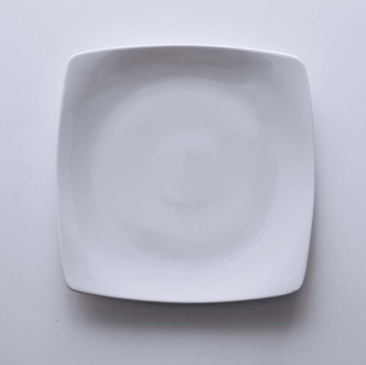 pottery empty ceramic plate on white textile grey