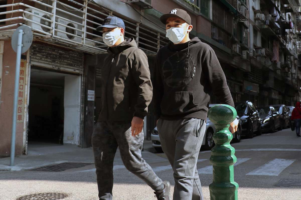 apparel man in black leather jacket and white helmet standing near green water dispenser person