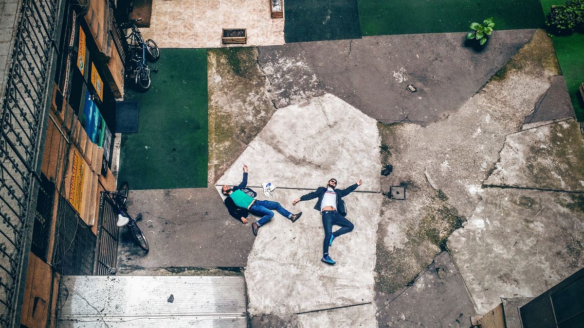 aerial view of two men lying on concrete pavement