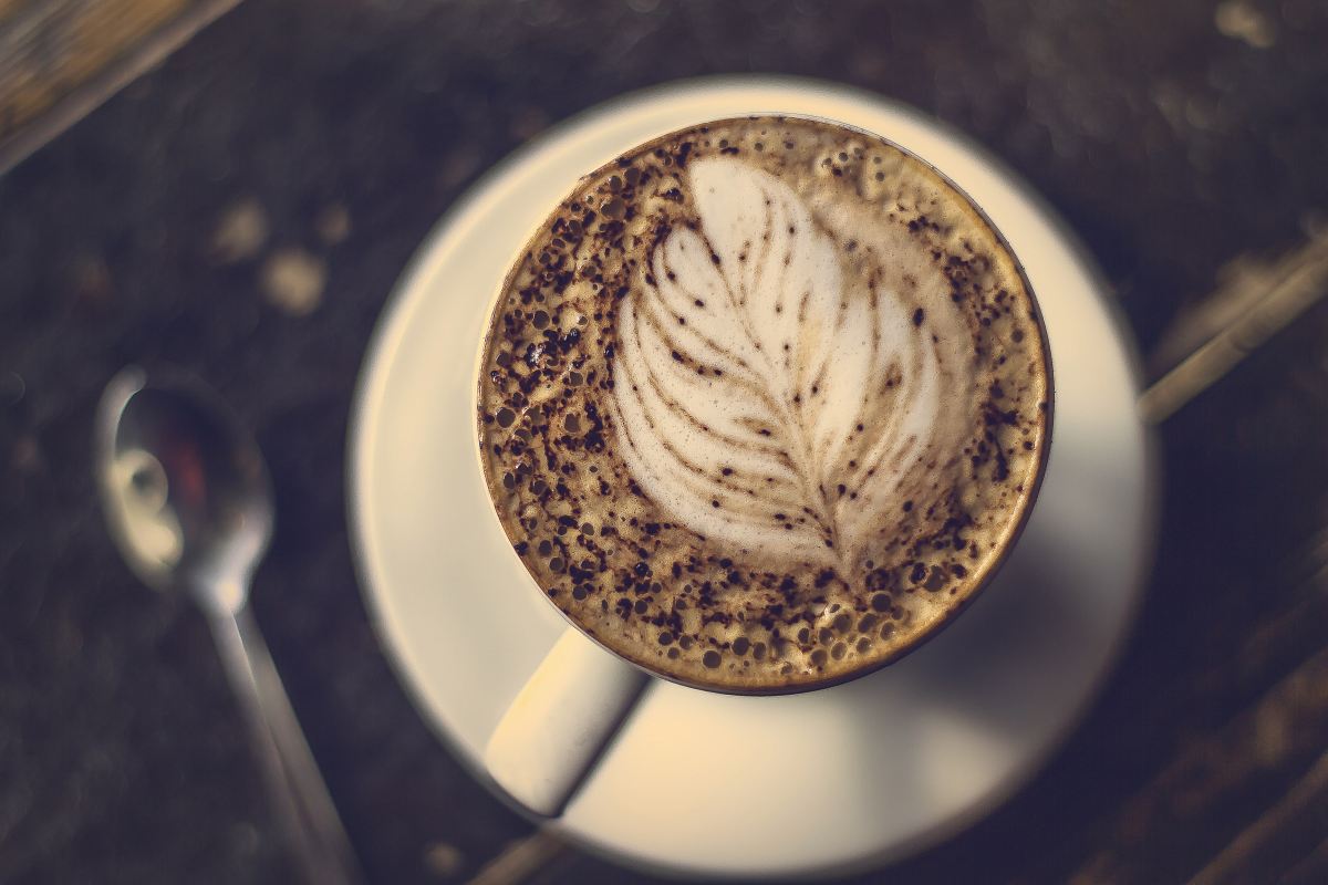 beige coffee with feather art near spoon