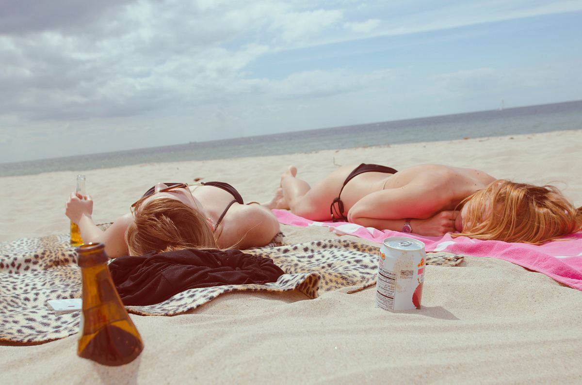 brown glass bottle across two women