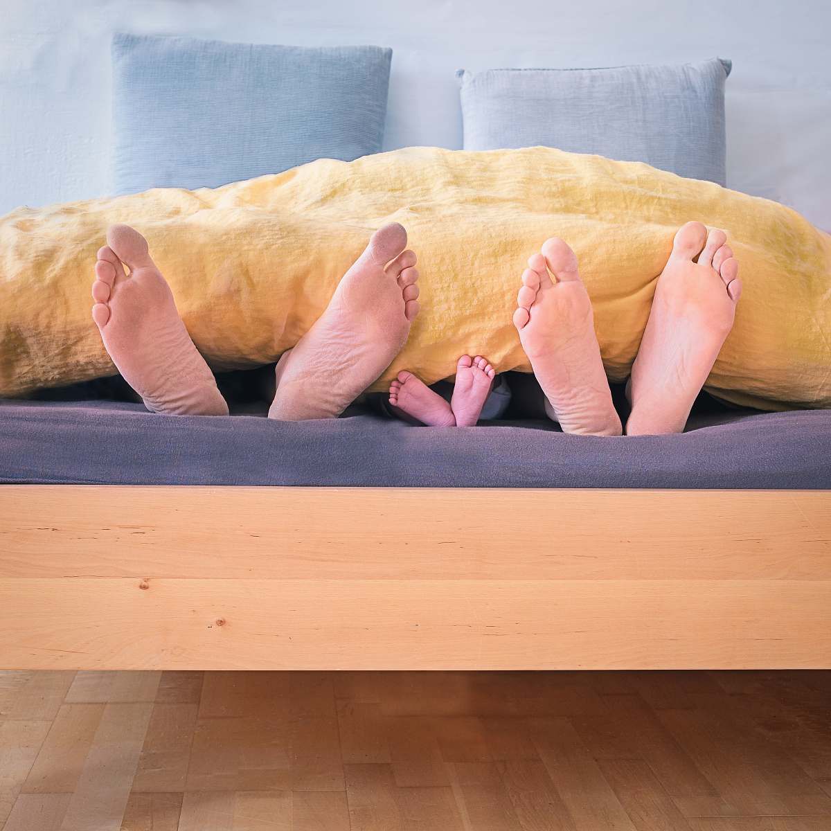 sleep three people underneath yellow bed blanket feet