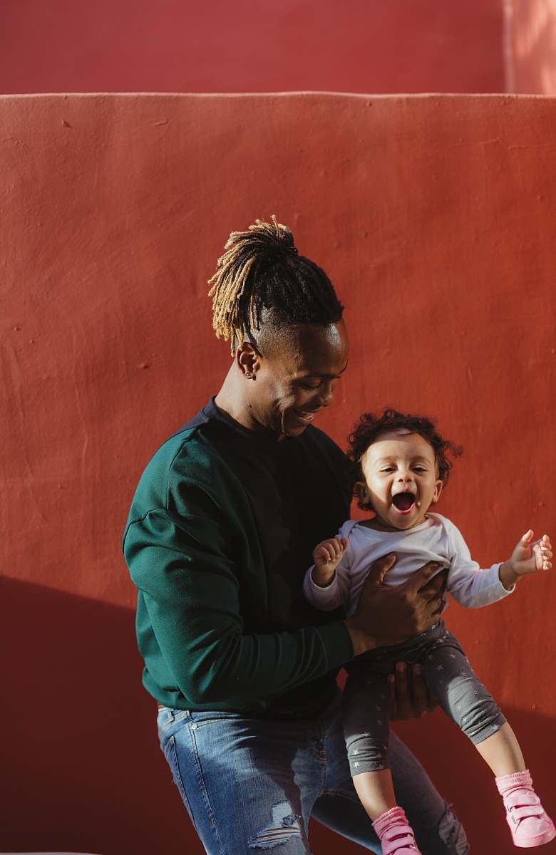 family smiling man carrying child and playing person