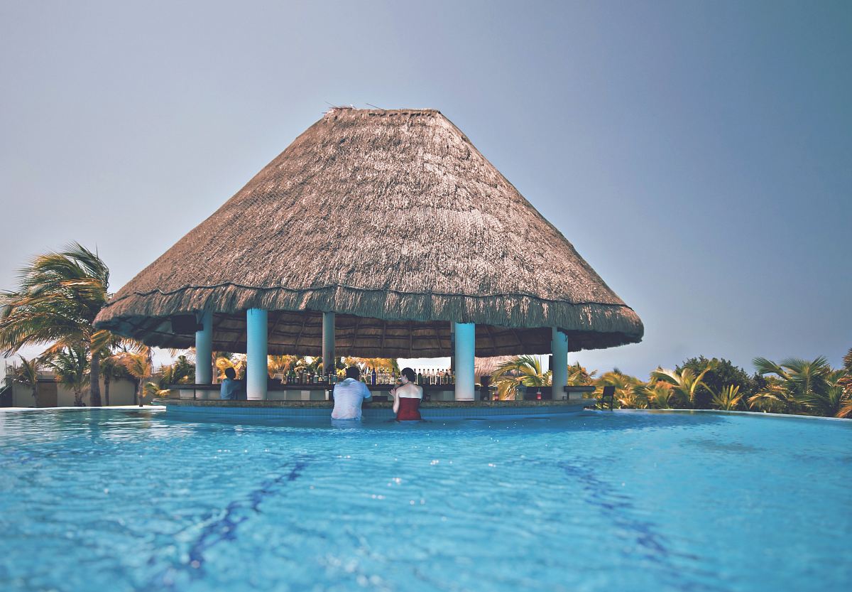 man and woman in blue pool under cottage at daytime