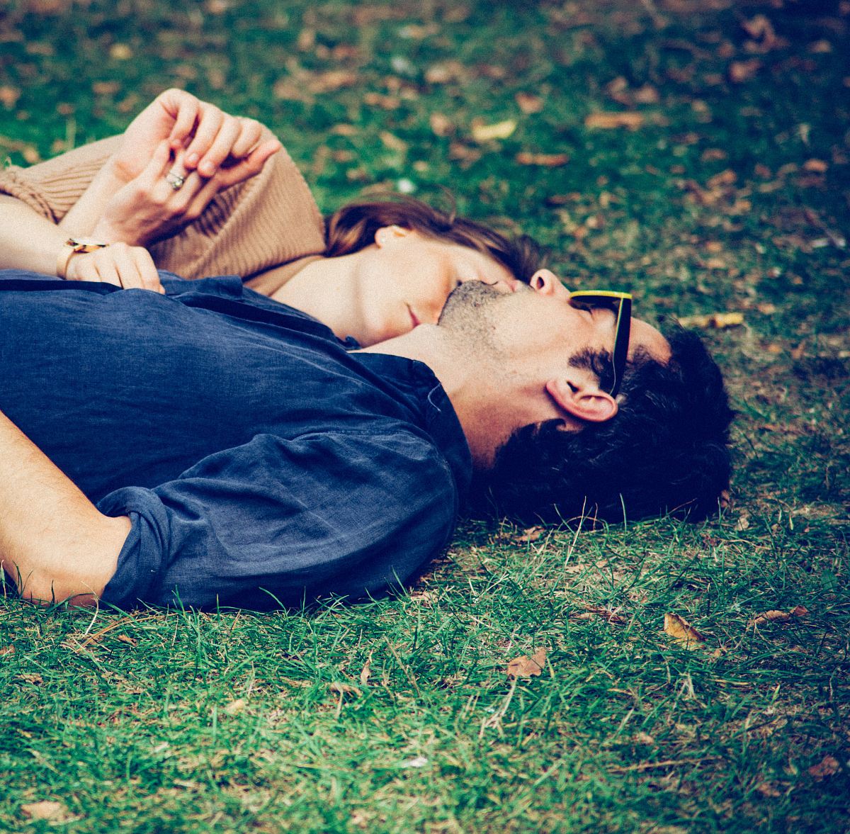 man and woman lying on grass