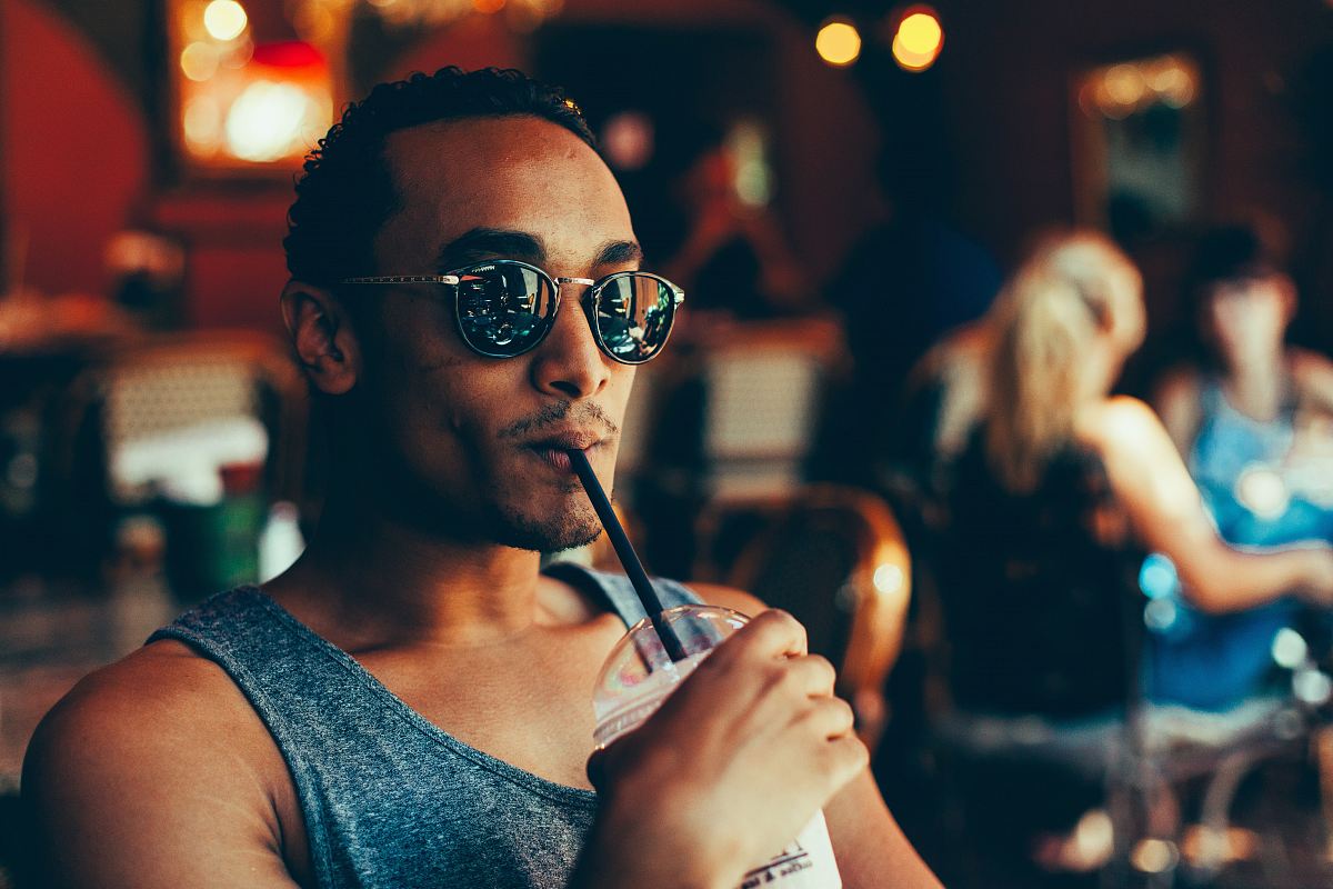 man sipping cooler while sitting on chair