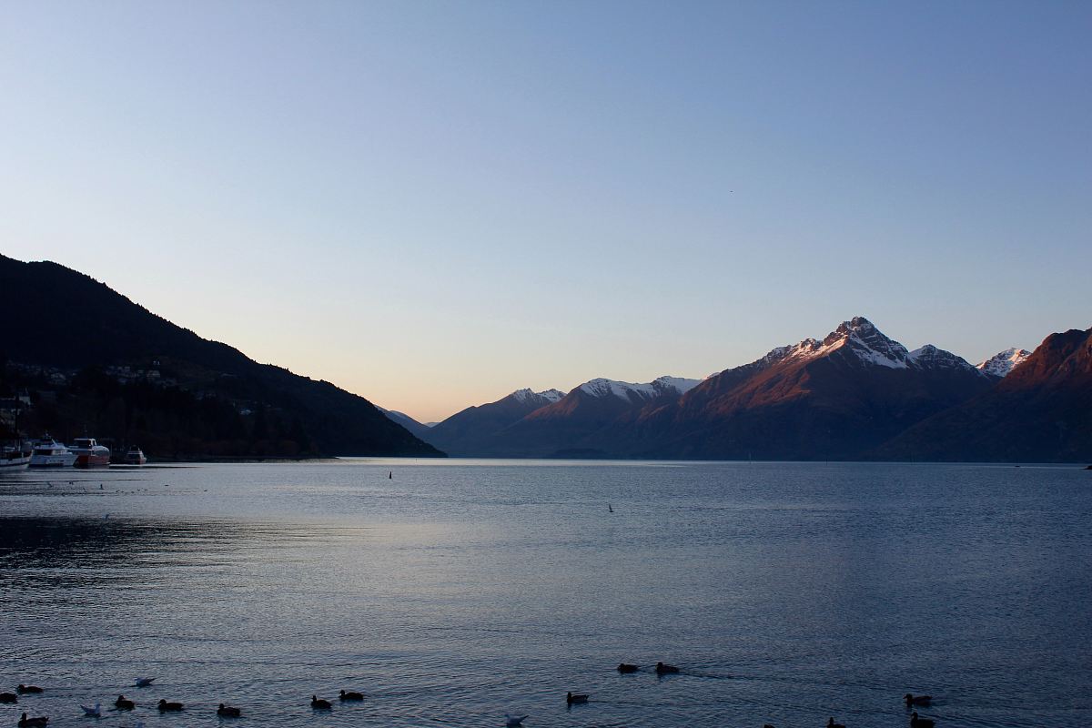 photography of calm body of water near mountains at daytime