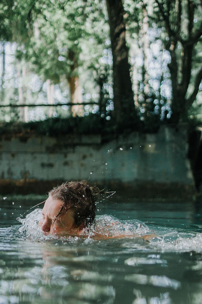 woman swimming on body of water during daytime
