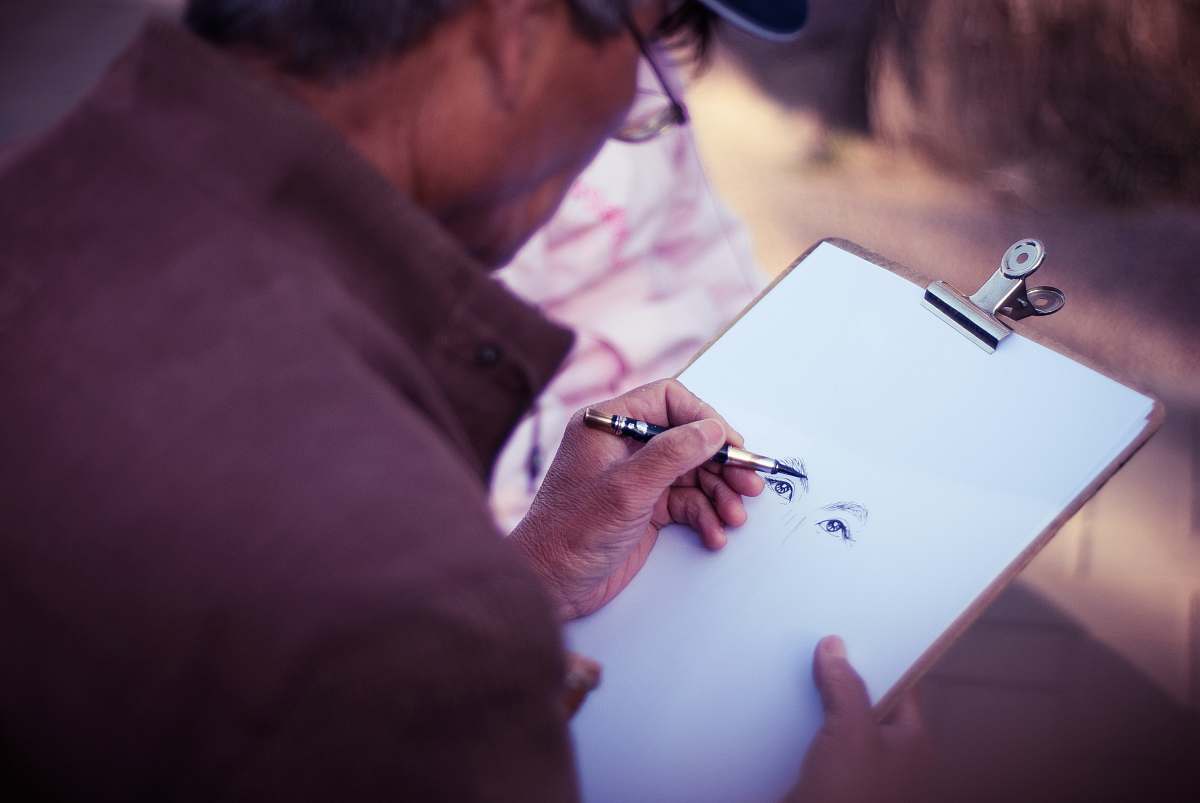 human man sketching face on white printer paper person