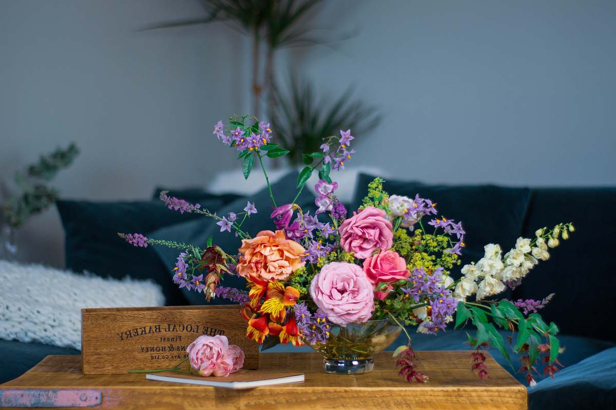 Capture the essence of nature with this stunning floral design featuring a variety of vibrant flowers elegantly arranged in a vase on a rustic wooden table. Ideal for enhancing your home decor, marketing materials, or artistic projects, this image evokes a sense of warmth and tranquility, making it perfect for any creative endeavor. Let the beauty of flowers inspire your designs and bring a touch of nature indoors.