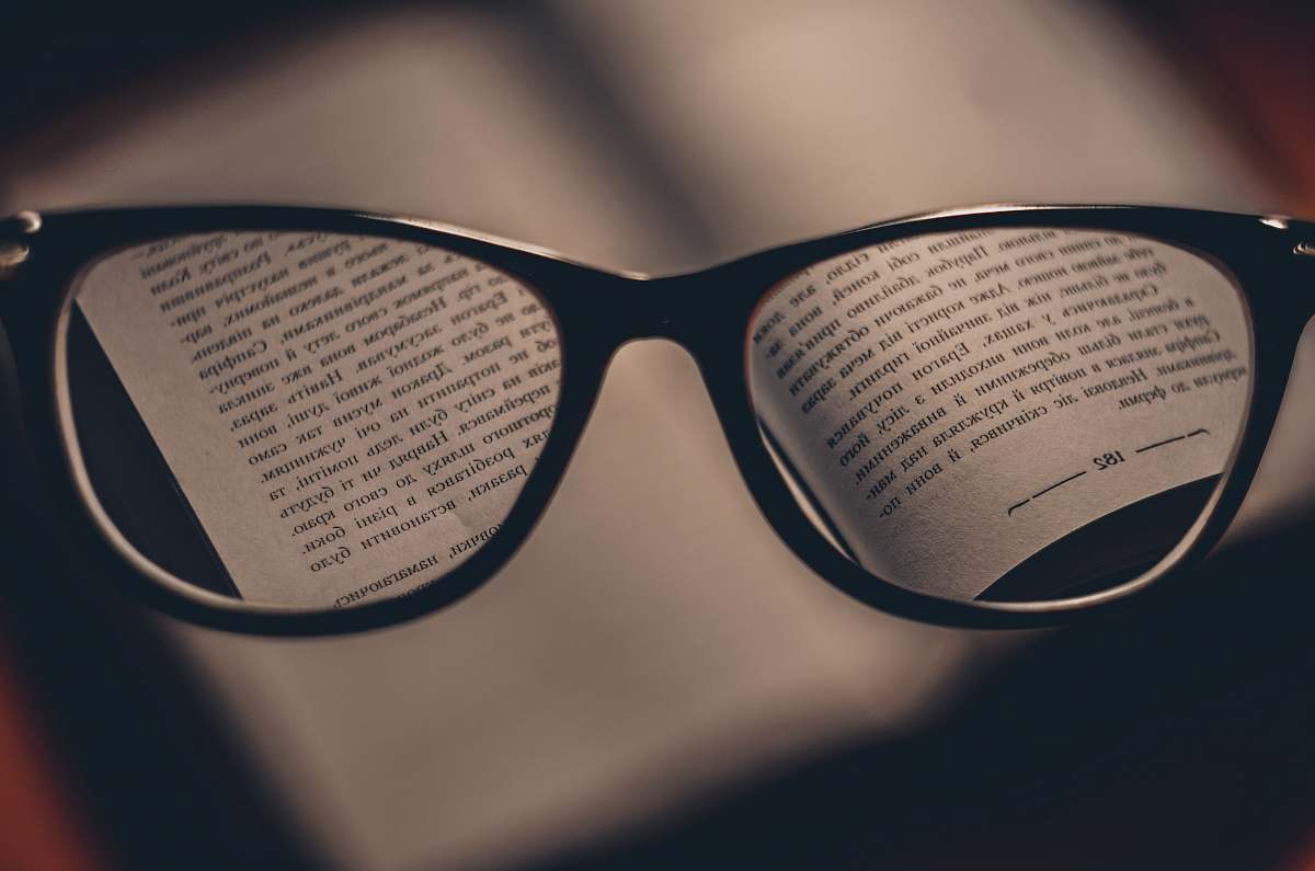 reading black text reflect on eyeglasses book