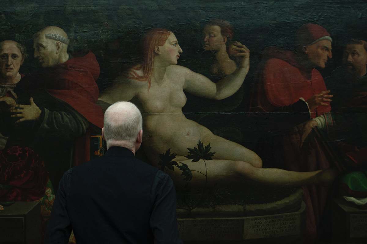 art man standing near painting person