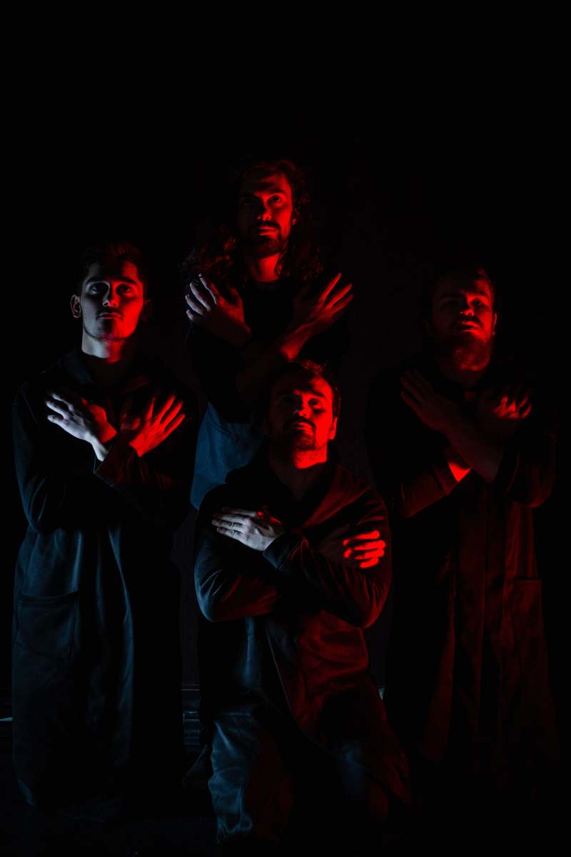 human four men standing with hands on chest person