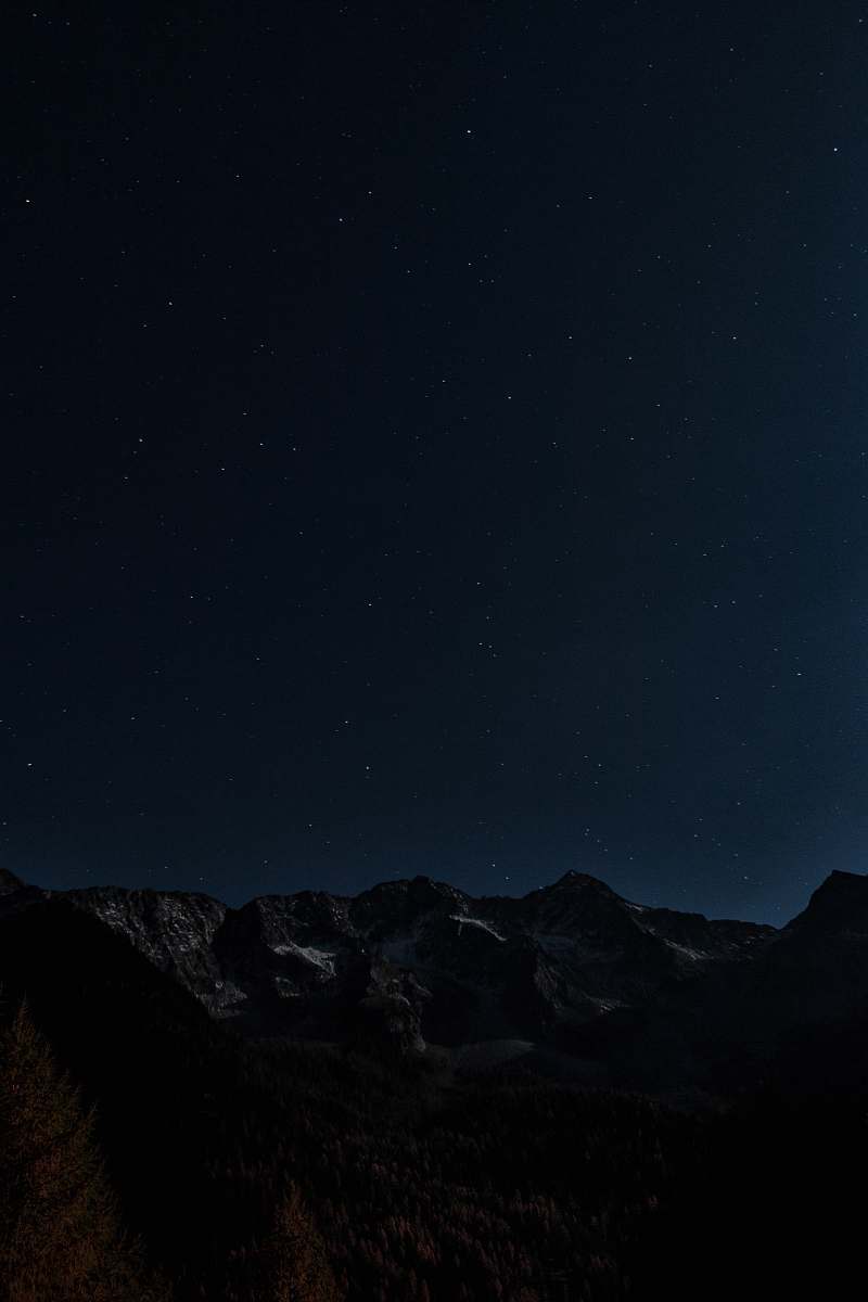 night gray and brown mountains under starry night photo outer space