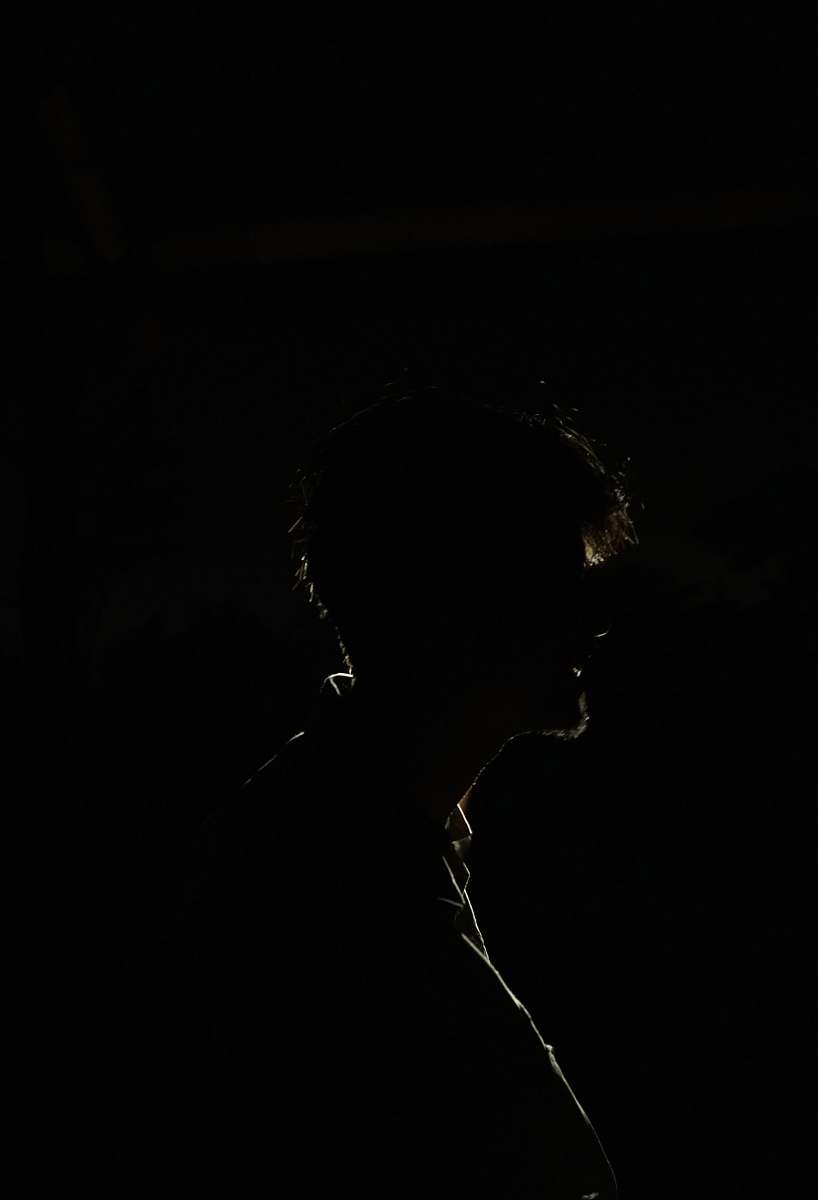 black-and-white silhouette of man in dark room silhouette