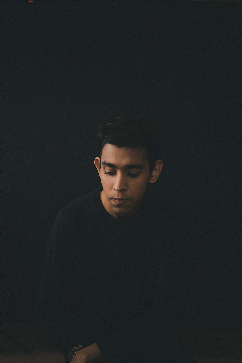 person man wearing black long-sleeved shirt sitting while looking down people