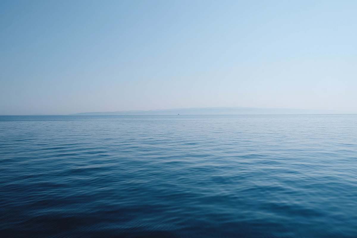 water body of water under blue and white sky at daytime sea