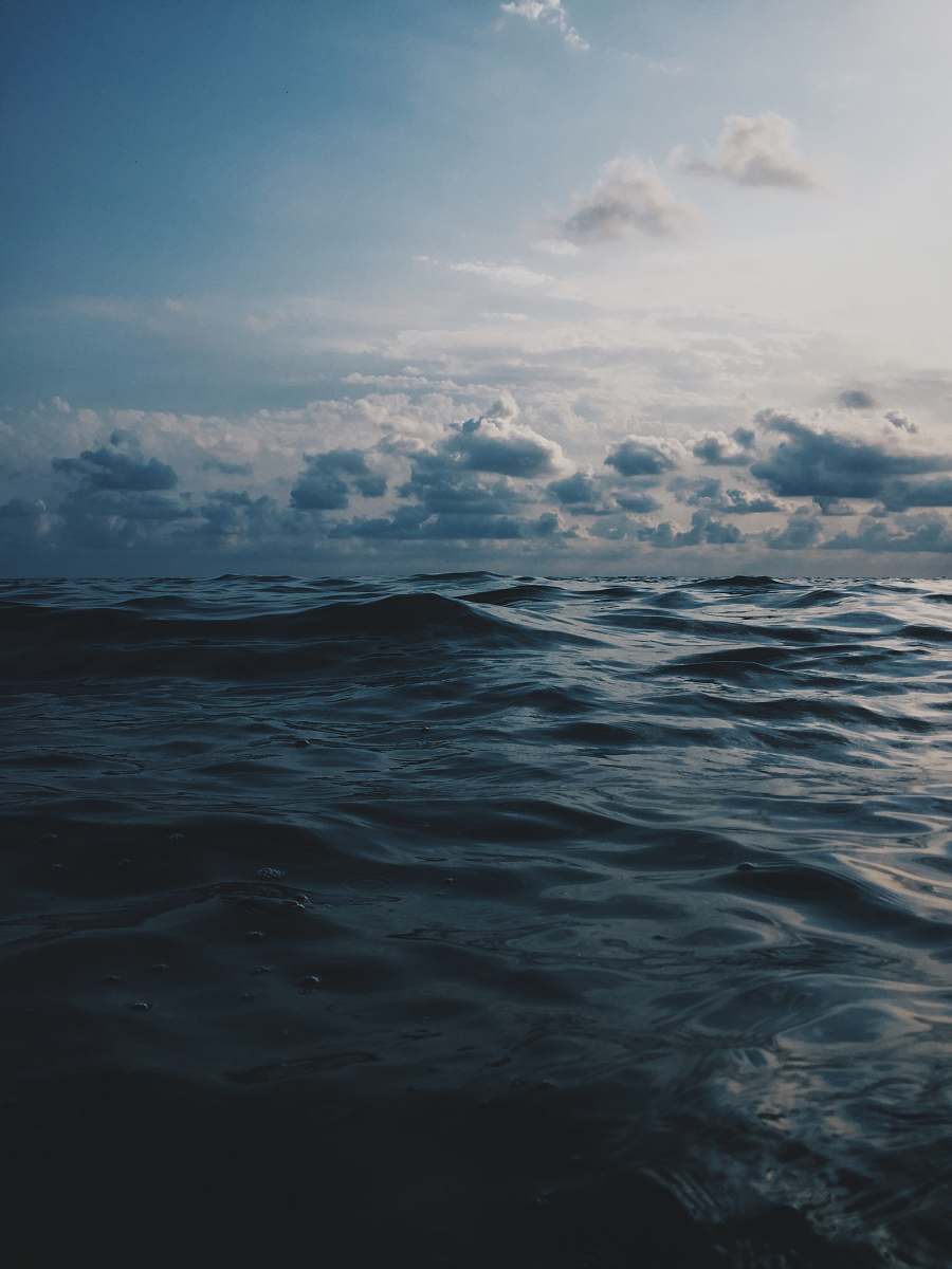 water sea under white clouds during daytime sea