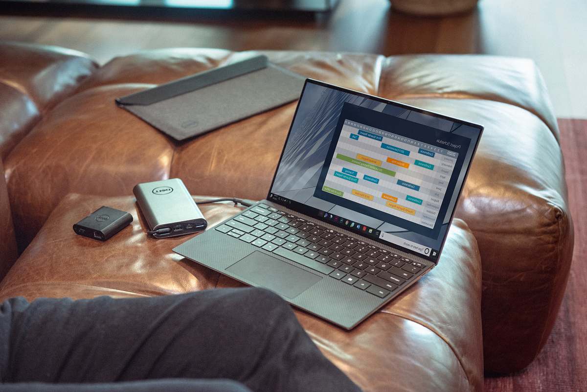 pc black and gray laptop computer on brown leather couch computer
