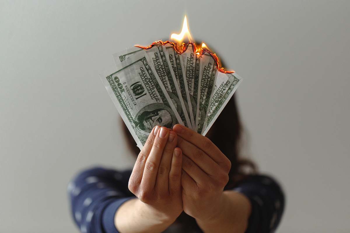 human a fan of fake American dollars on fire person