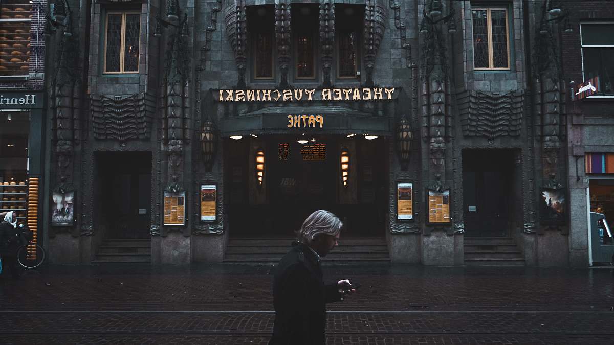 amsterdam man standing near Theater Tuschinski building human