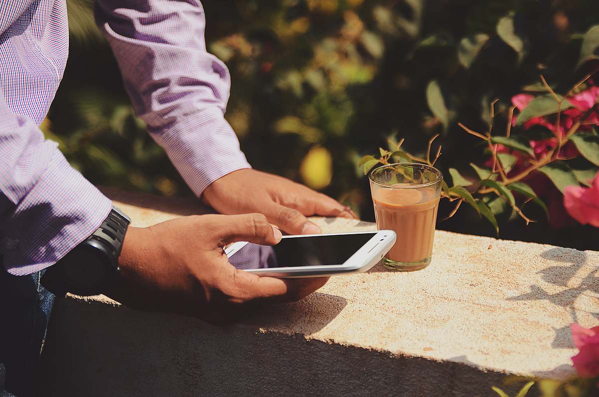 people man using smartphone beside drinking glass drink