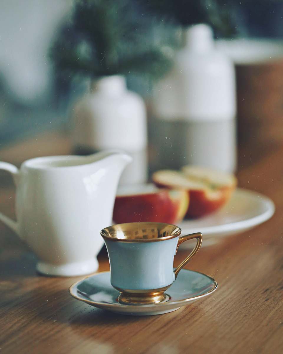 pottery selective focus photography of teacup beside two slices of apple cup