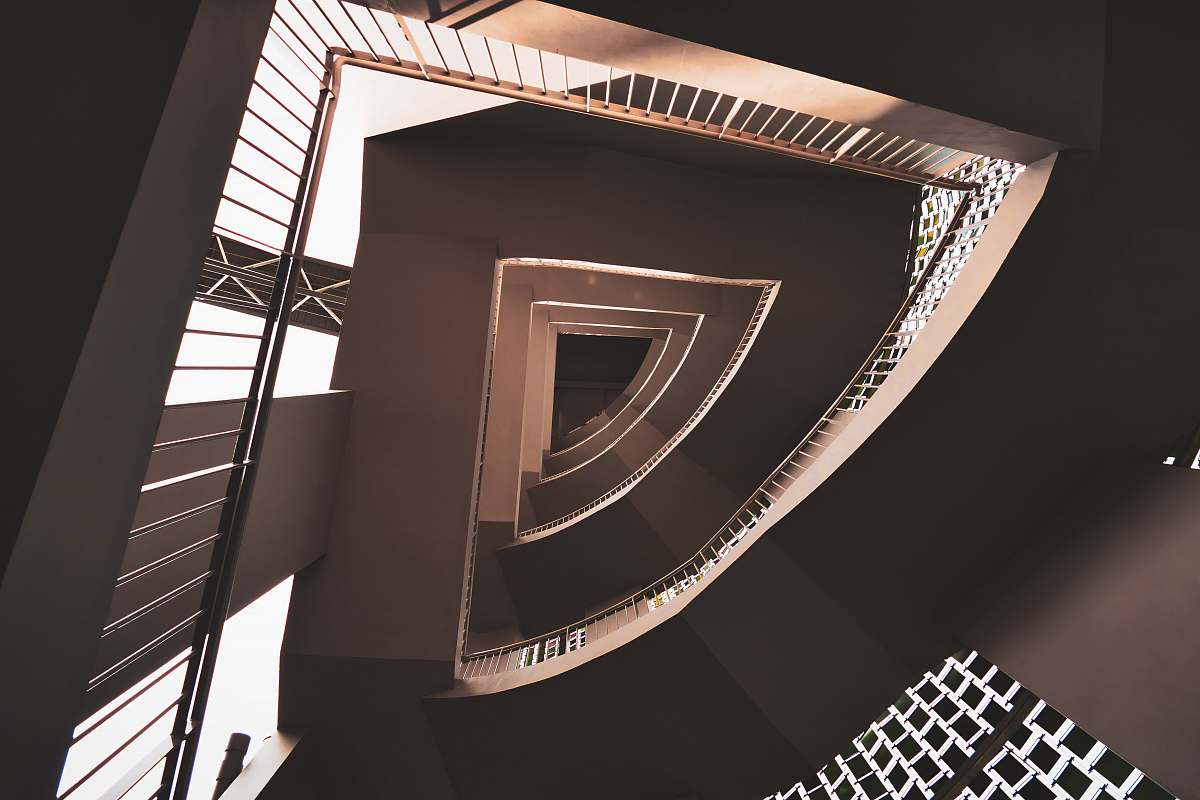 spiral low-angle photography of concrete stair building